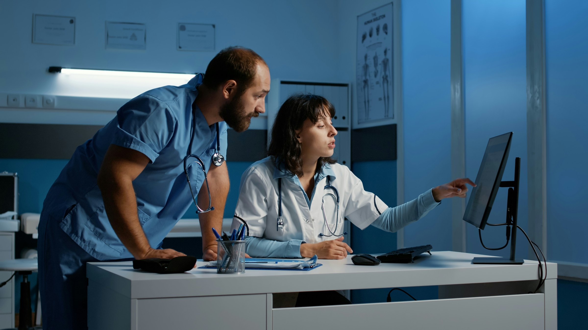 Hospital staff reviewing operational records on a workstation.